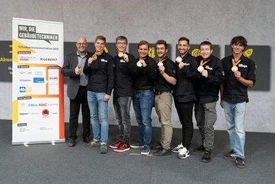 Une photo de 7 lauréats avec leurs prix accompagnés du direteur de suissetec